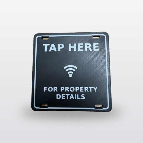 NFC A-Frame Sign Tag: real product photo, black tag with raised white TAP HERE, tap icon and FOR PROPERTY DETAILS, on a studio background