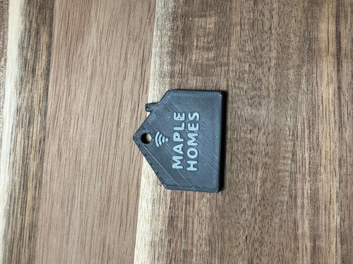 Real printed NFC house keychain lying flat, showing print layer lines