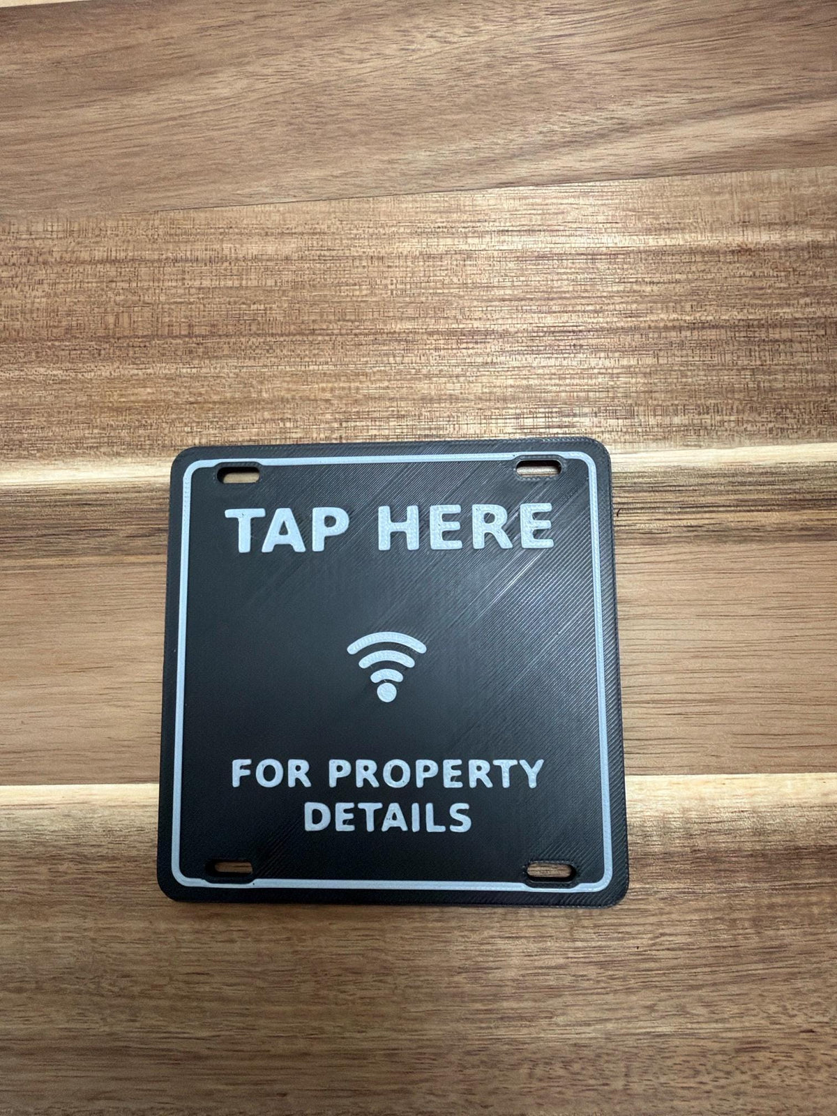 Real printed NFC A-frame tag on a wood table, unedited
